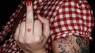 Woman with tatoos giving the finger | Bild: picture alliance / Westend61 | Stefan Kranefeld