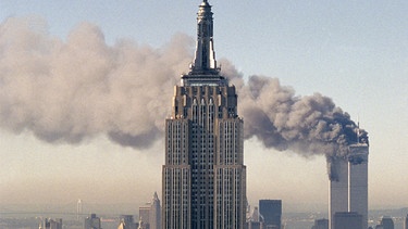 Das brennende World Trade Center hinter dem Empire State Building am 11. September 2001. | Bild: picture alliance / ASSOCIATED PRESS | Marty Lederhandler